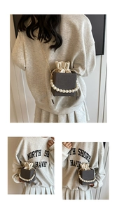Detail of dark grey textured box bag featuring pearl handle and cream drawstring lining