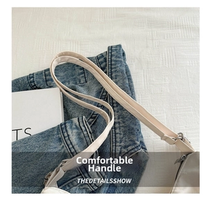 Detail of the white shoulder bag featuring slim synthetic leather straps and fine stitching