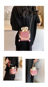 Detailed pink woven box bag featuring premium imitation pearl handle and gold chain strap