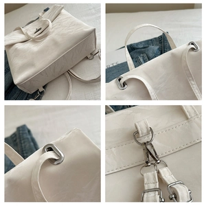 Détails d'un sac à dos blanc plissé brillant avec boucles et ferrures en métal argenté