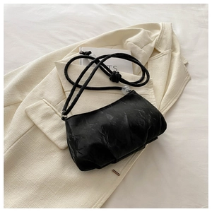 Detail of black pleated cloud bag with elegant crystal beads and soft texture