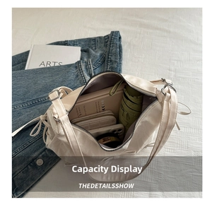 Spacious interior of white bow shoulder bag holding umbrella, notebook, and phone