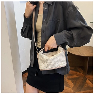 Detailed straw texture of a chic woven handbag with pinkish-brown leather straps