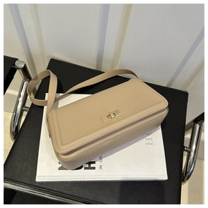 Close-up of beige tote bag with light gold twist lock and neat stitching details