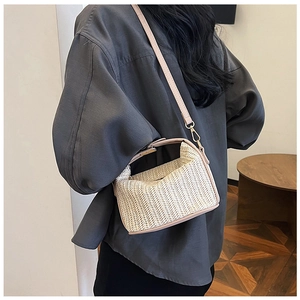 Detail of summer straw crossbody bag with V-shaped weave and pink leather straps