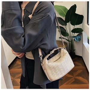 Detailed V-shaped texture on a straw woven crossbody bag with gold-tone hardware
