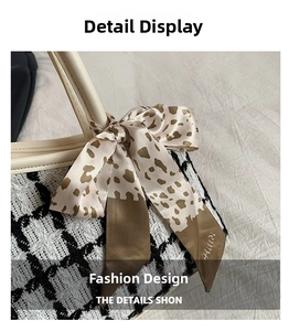 Detail view of black and white tweed bag handle with leopard print silk ribbon knot