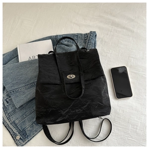 Detail view of the silver twist lock and crinkled texture on a black versatile bag