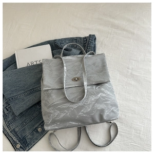 Detail of silver metallic tote bag with crumpled texture and stylish silver metal turn-lock