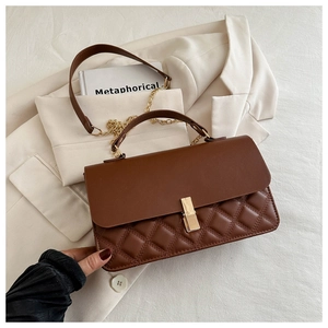 Details der kaffeebraunen Stepptasche mit Goldschließe und Kettengurt von Model gehalten