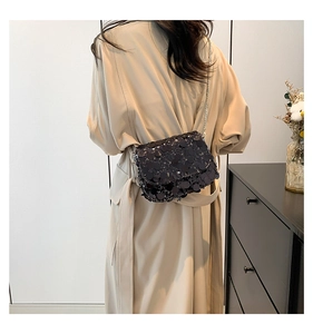 Detailed back view of a black sequin crossbody bag with a slim silver chain strap
