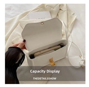 Detail view of the open white faux leather crossbody bag showing interior capacity