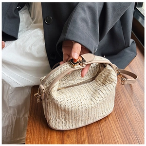 Detailed view of straw woven texture with golden metal clasp and leather trim on handbag