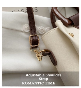 Detail of adjustable brown strap and gold metal buckles on a white crossbody bag
