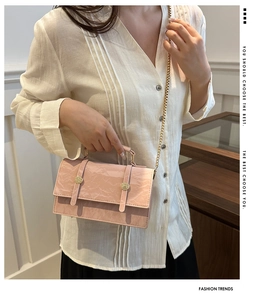 Sac à main rose en cuir verni plissé avec bandoulière chaîne dorée et détails dorés