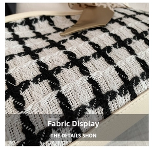 Detail of black and white tweed fabric texture with a champagne silk bow accent