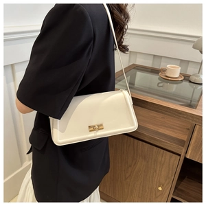 Detail of cream white leather shoulder bag with golden metallic swivel lock closure