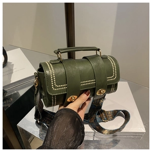Detail of dark green pillow bag showing white rivets and vintage ethnic wide shoulder strap