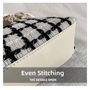 Detailed macro view of high-quality stitching on a woven black and white plaid tote bag