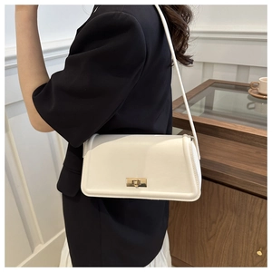 Detailed view of a white rectangular crossbody bag with a gold metal twist lock and slim strap