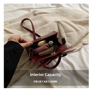 Internal view of a small wine red bow handbag showing lipstick and wallet capacity