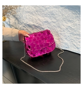 Detailed view of magenta sequin crossbody bag with metallic chain strap and flap closure