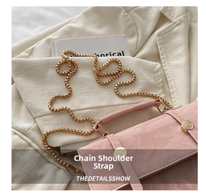 Pink embossed leather handbag with chunky gold chain strap and circular metal clasp