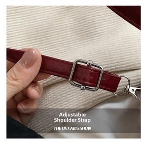 Detail of adjustable wine red leather shoulder strap with silver metal buckle and lobster clasp