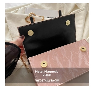 Detail of pink marble pattern bag showing four gold metal magnetic snaps and golden chain