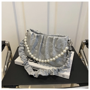 Dettaglio borsa a nuvola plissettata argento con catena di perle e finitura satinata