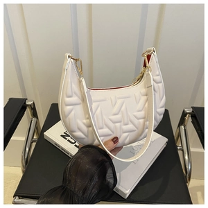 Detail of white crescent bag with T-shaped embossed quilting and red lining detail