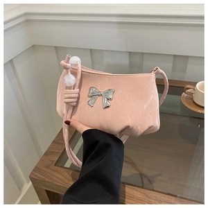 Detail of pink ruched underarm bag with silver bow buckle and pearl strap accents