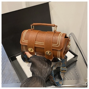 Detail of retro brown Boston bag with wavy stitching and ethnic patterned wide strap