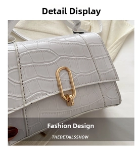 Detail shot of white crocodile texture faux leather with golden oval metal clasp closure