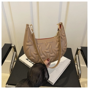 Detail view of khaki crescent shoulder bag featuring geometric quilted embossed patterns