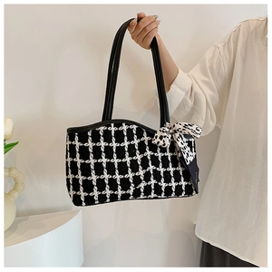Detail of checkered tweed tote bag featuring black handle and leopard print silk scarf