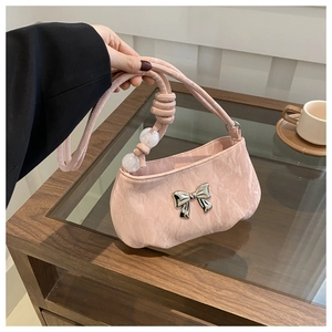 Detail view of pink pleated shoulder bag with silver bow buckle and bead accents