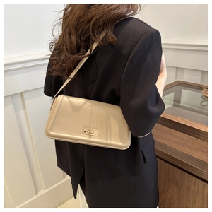 Detail of a chic beige rectangular crossbody bag with a gold square twist lock