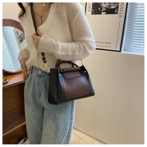 Detail of a vintage contrast color crossbody bag with leather texture and rivet accents