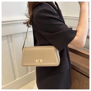 Chic beige rectangular shoulder bag with gold twist lock shown on model for elegant look