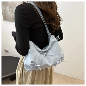 Détail du sac à bandoulière bleu clair plissé avec d'élégants nœuds décoratifs