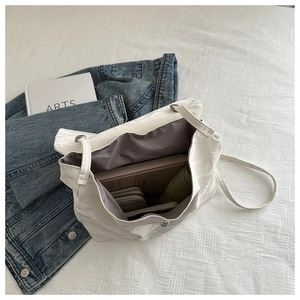 Top view of large white pleated shoulder bag showing spacious interior with daily essentials