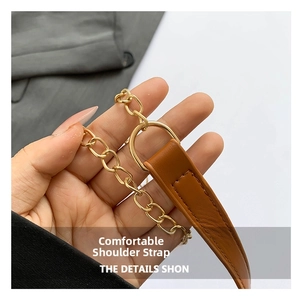 Detail of brown litchi pattern leather shoulder strap with gold metal chain and D-ring