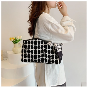 Classic black and white tweed checkered shoulder bag with silk scarf accent on model