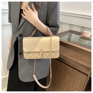 Detailaufnahme der cremefarbenen Stepptasche mit goldenem Verschluss und Kettenriemen
