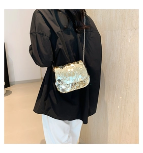 Golden sequin flap crossbody bag with metal chain strap shown as a stylish shoulder bag