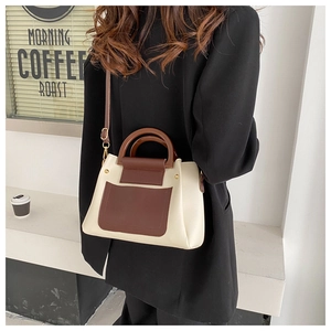Detailed view of bicolor crossbody bag with metal gold hardware and leather texture