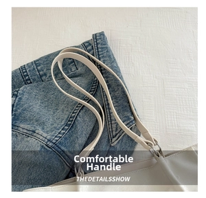 Close-up of dual slender straps on a white PU leather tote bag with denim background