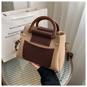 Detail view of the vintage contrast-color handbag with wooden handles and gold rivets