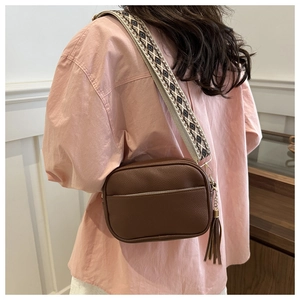 Brown lychee leather crossbody bag with bohemian wide strap and tassel detail